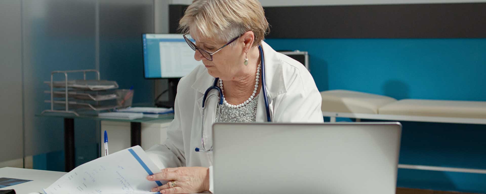Female healthcare professional reviewing documents at her desk, representing medical billing companies in San Antonio, TX.